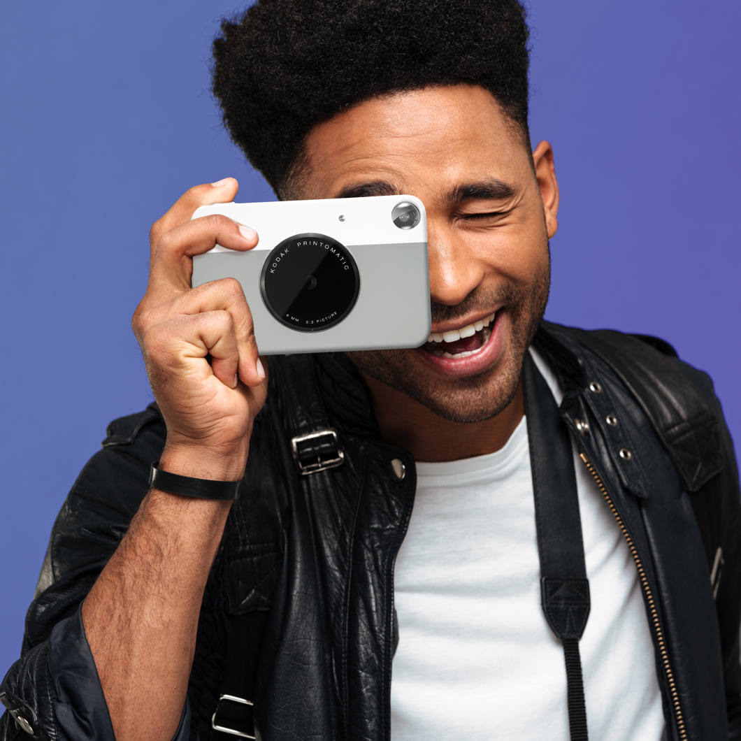 Kodak Printomatic instant compact camera with black body and lens, ready to capture and print photos instantly.