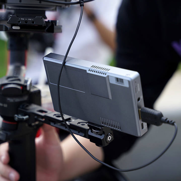 Feelworld P6XL 6-inch camera field monitor displaying detailed video interface and control buttons for professional video monitoring.