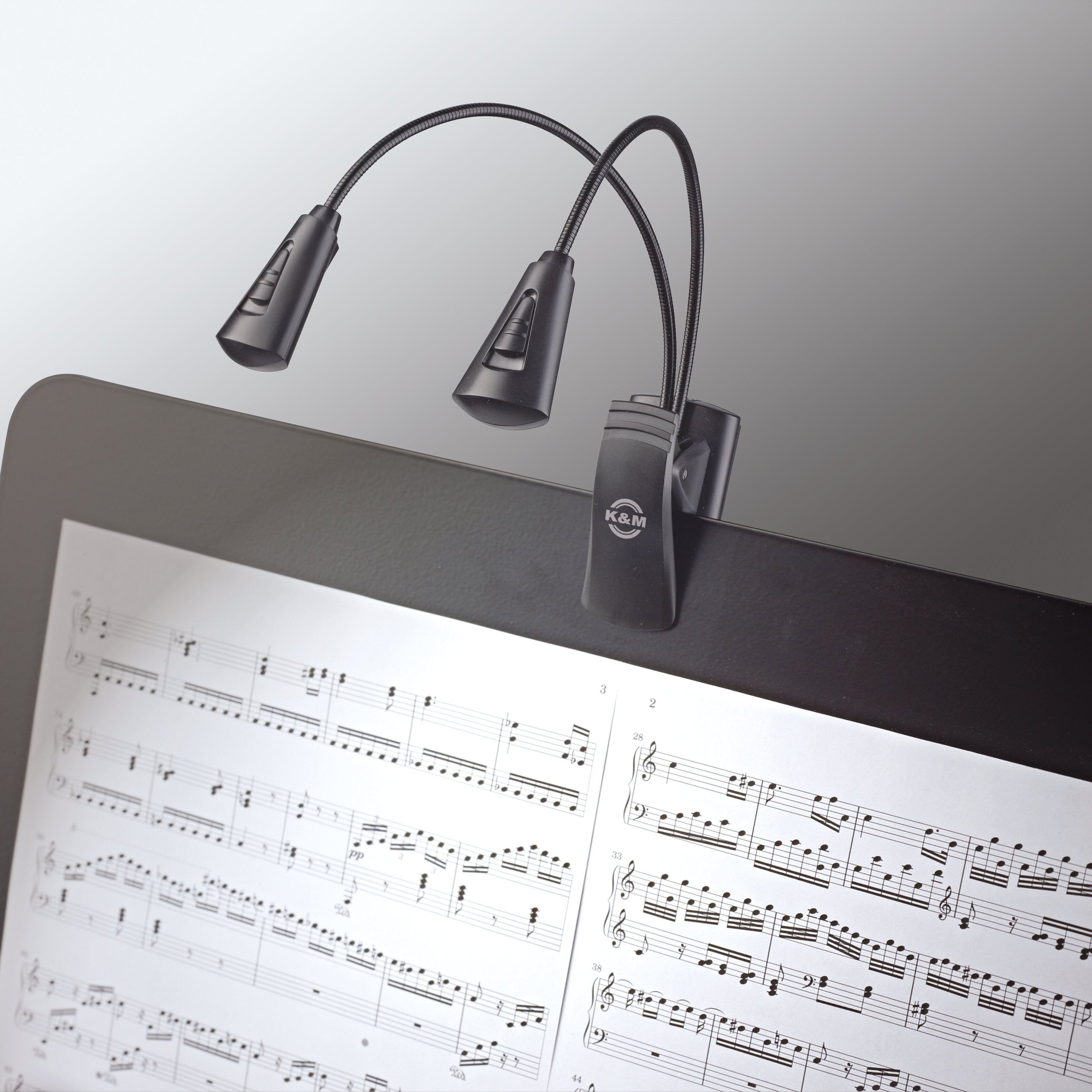 K&M 12244 music stand light attached to a music stand, adjustable LED lamp for sheet music illumination.