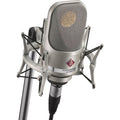 Neumann TLM 107 condenser microphone studio set with microphone, shock mount, and cables on a neutral background.