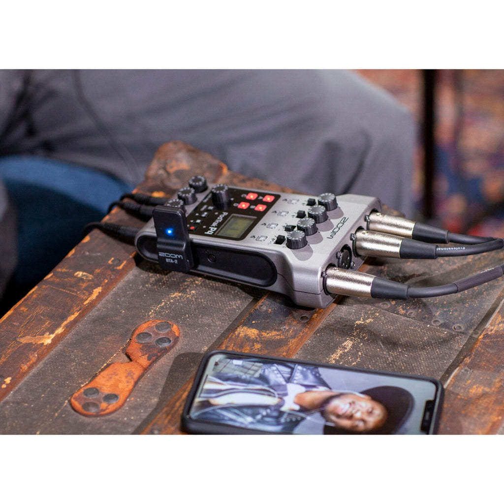 Zoom BTA-2 Bluetooth adapter for PodTrak P4 and P8 recorders, shown connected to audio equipment.