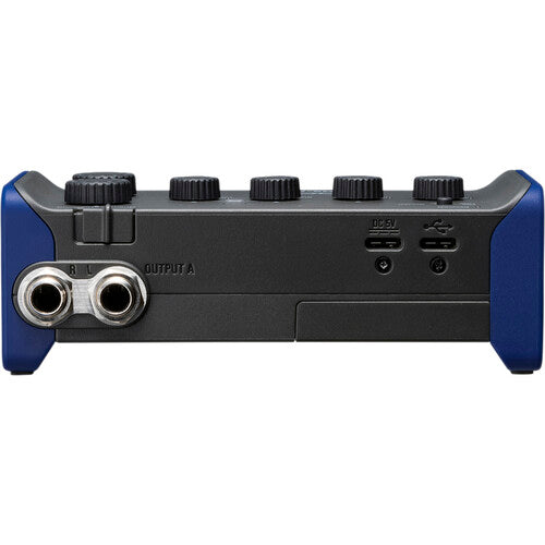 Zoom AMS-44 audio interface with multiple input/output ports and a sleek, compact design on a wooden surface.