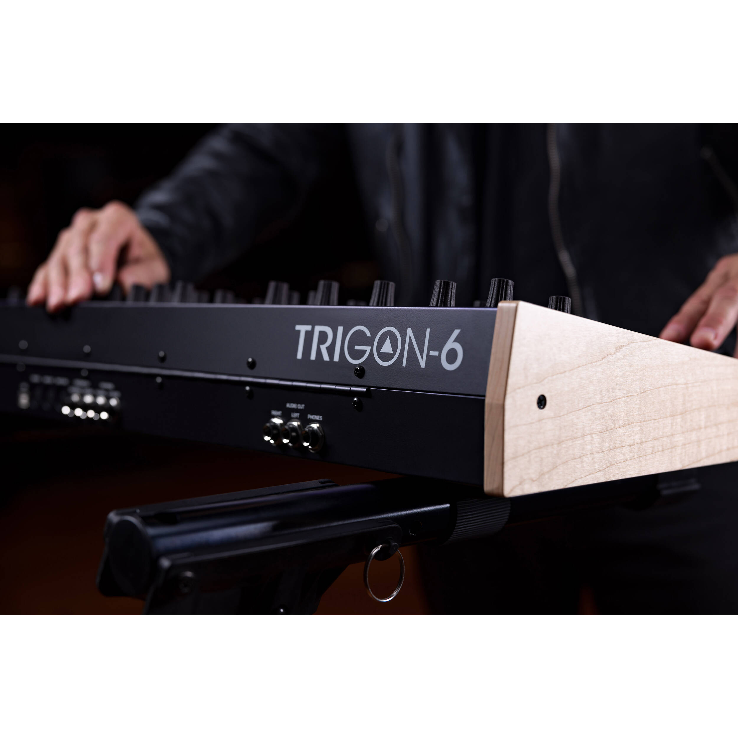Sequential Trigon-6 synthesizer with a sleek black design and various control knobs and buttons on the front panel.