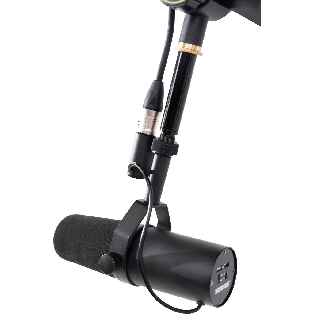 Shure SH-BROADCAST1 broadcast microphone arm mounted on a desk, adjustable metal arm with cable management for professional audio setup.