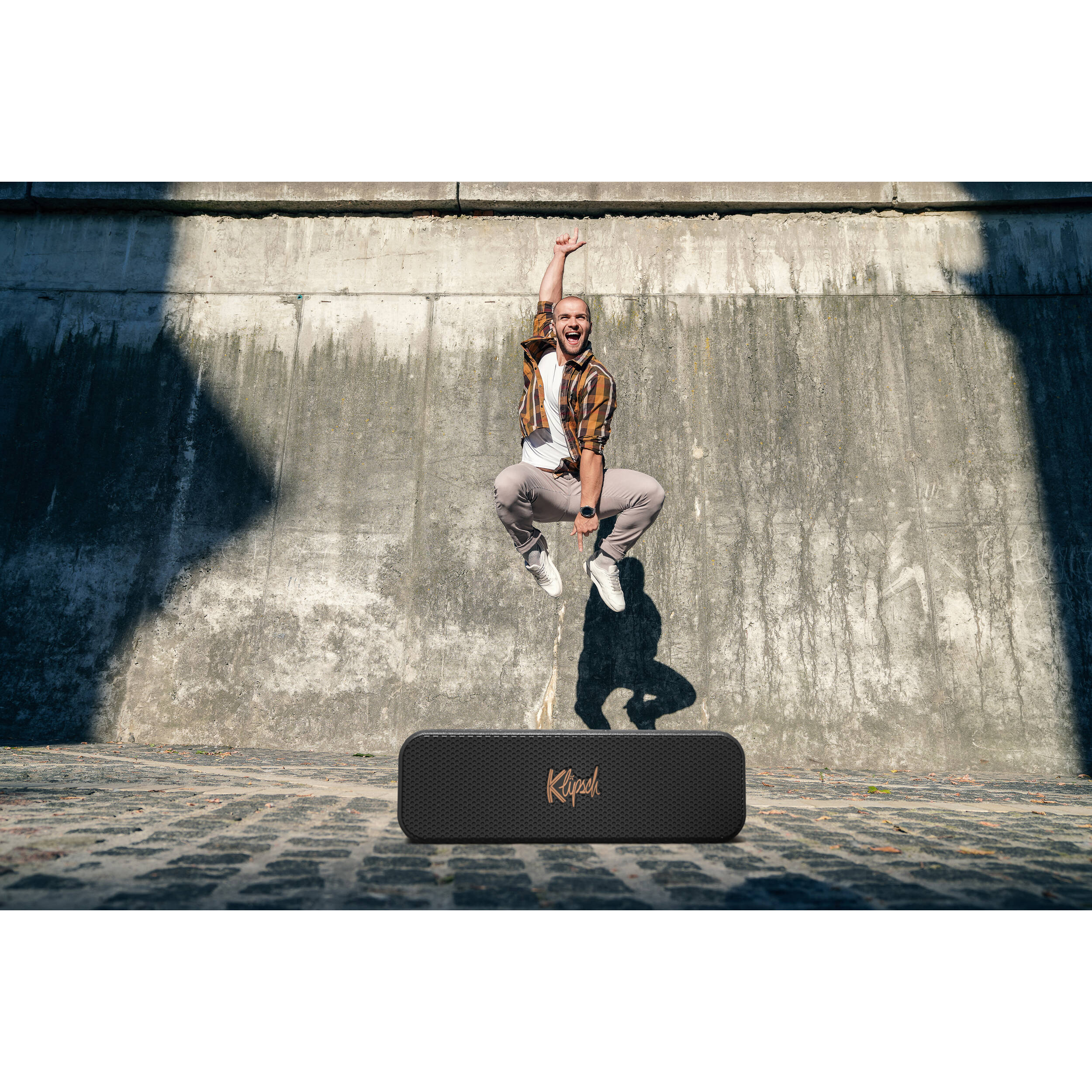 Klipsch Detroit portable speakers with sleek design and rich sound quality on a wooden surface.