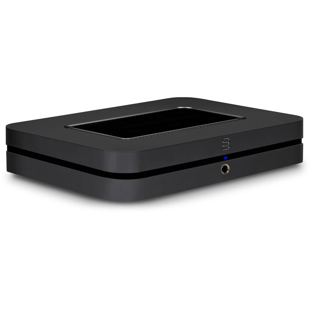 Bluesound Node 2025 black music streamer connected to audio equipment, showcasing sleek design and modern streaming features.