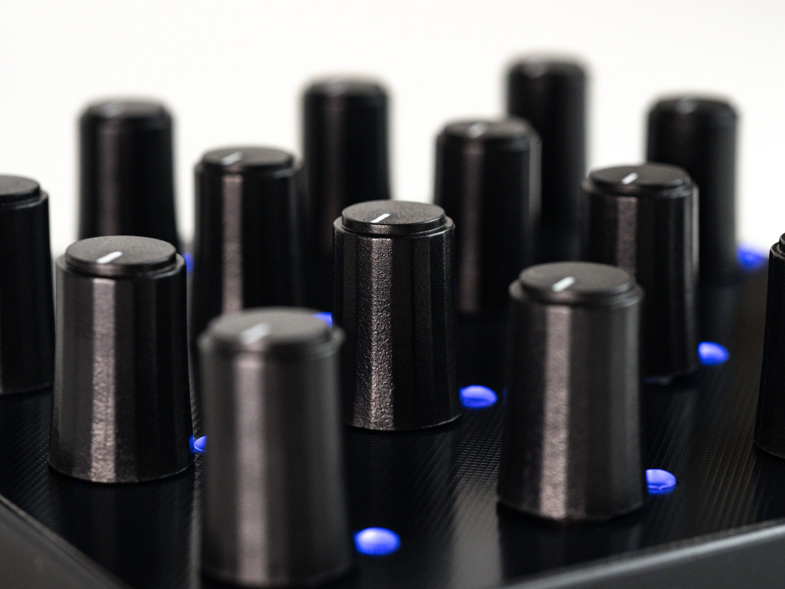 Close-up of Intech Studio PO16 Series 3 MIDI controller with knobs, buttons, and a sleek black design for music production.