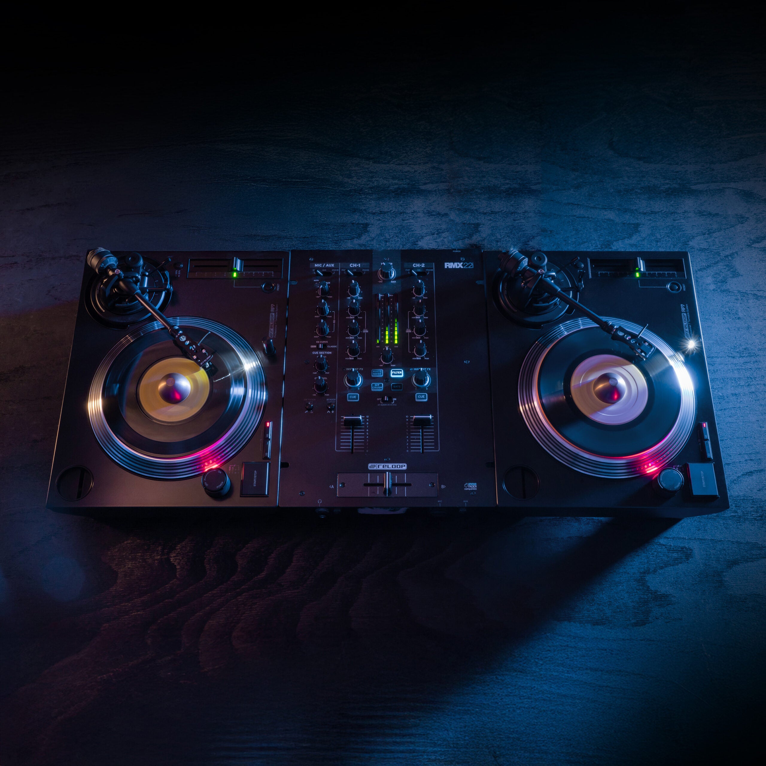 Reloop RP-7 DJ turntable with vinyl record, professional audio equipment, and control knobs on a sleek black surface.