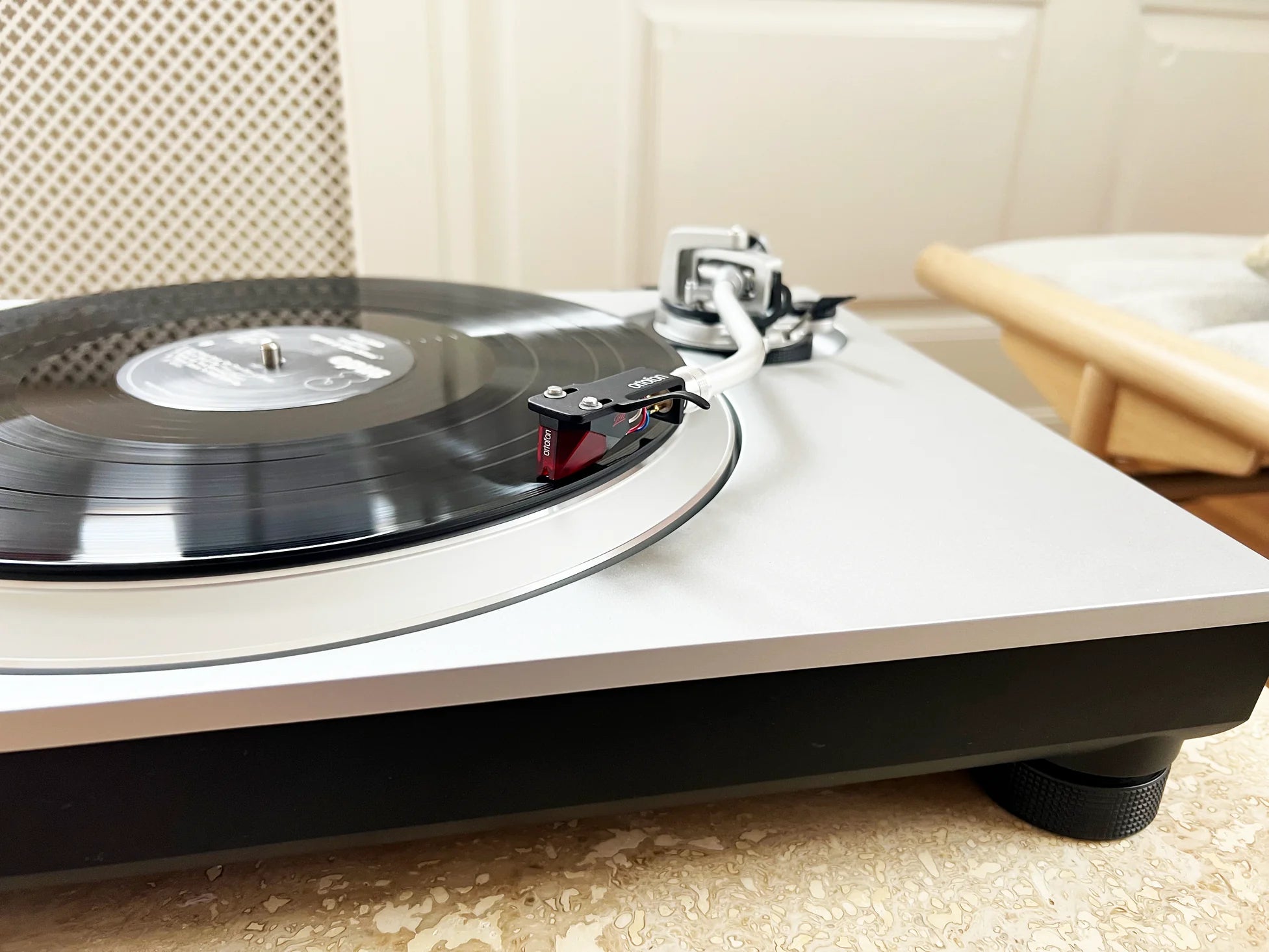 Ortofon 2M Red Verso turntable cartridge mounted on a turntable with a stylus, showcasing high-quality audio equipment.