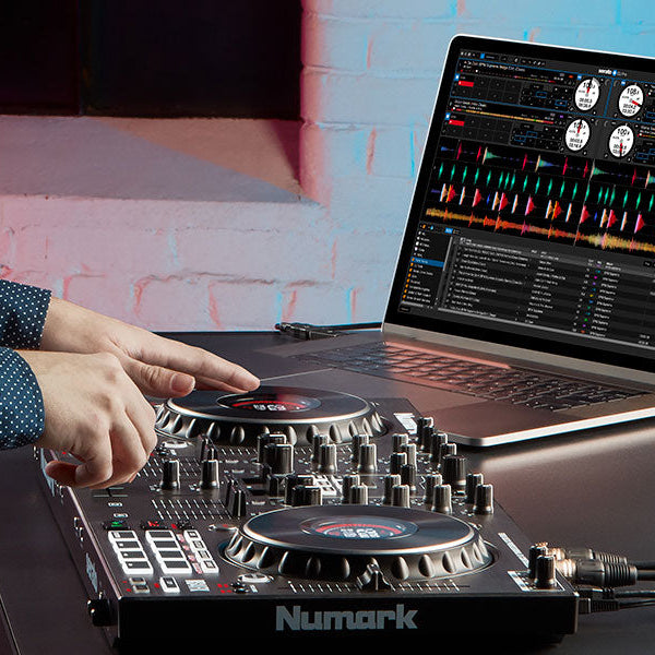 Numark NS4FX DJ controller with four-channel mixer, jog wheels, and FX controls, displayed on a sleek black surface.