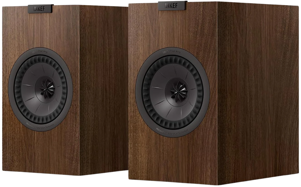 KEF Q3 Meta passive bookshelf speakers shown in a home audio setup with black cabinets and silver accents.
