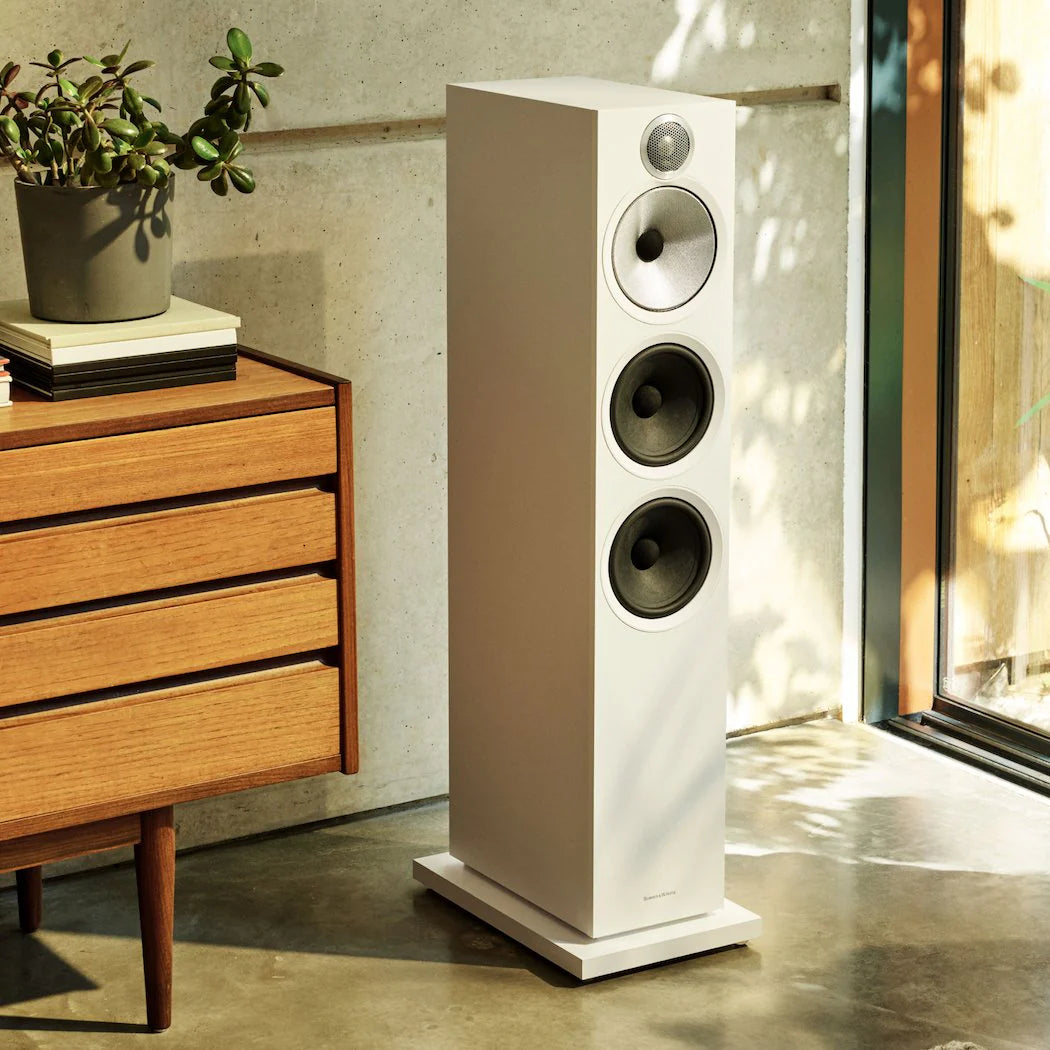 Bowers & Wilkins 603 S3 passive floorstanding speakers in white, shown in a lifestyle setting with sleek design and speaker grille.