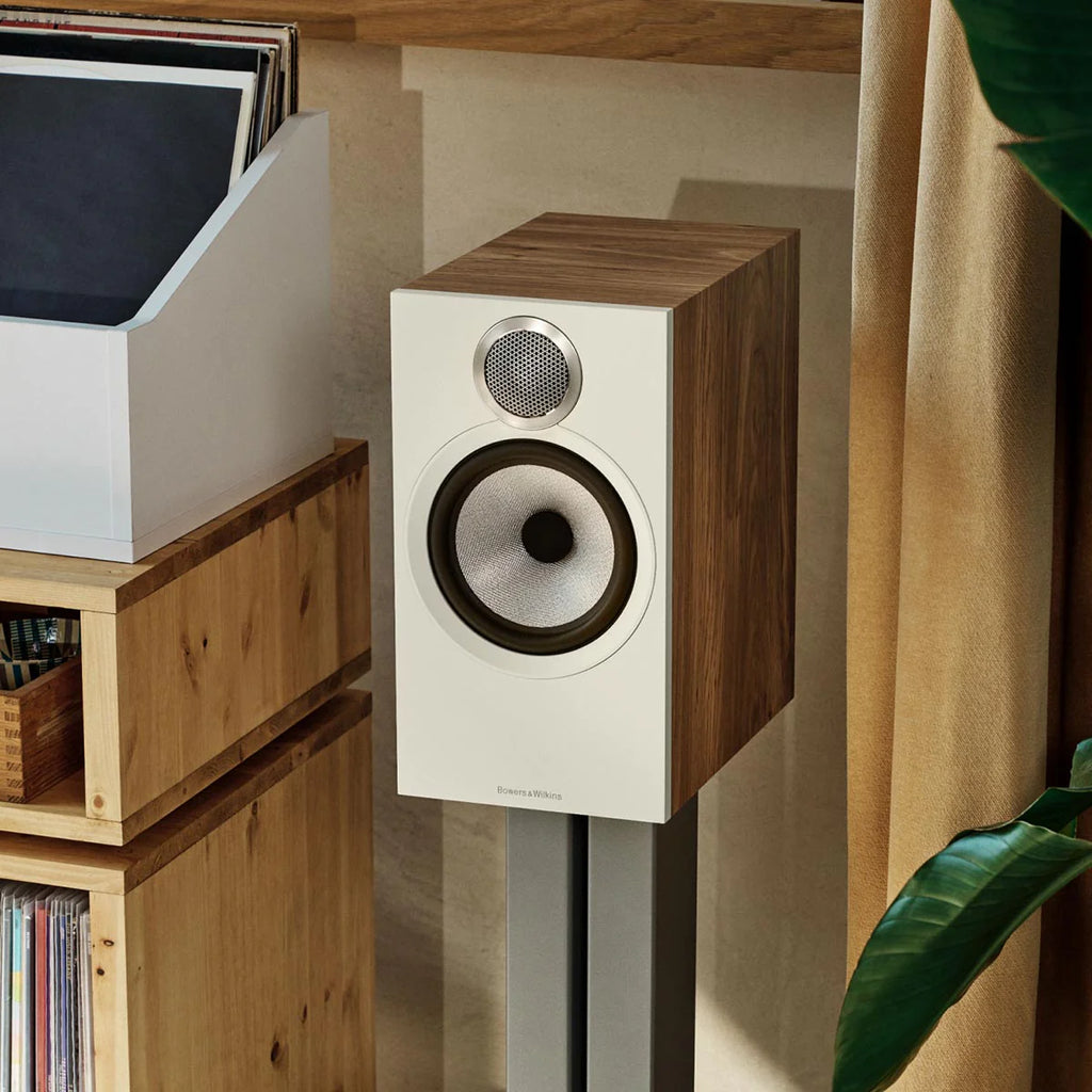 Bowers & Wilkins 606 S3 passive bookshelf speakers in oak finish, showcasing sleek design and speaker grille on a lifestyle setup