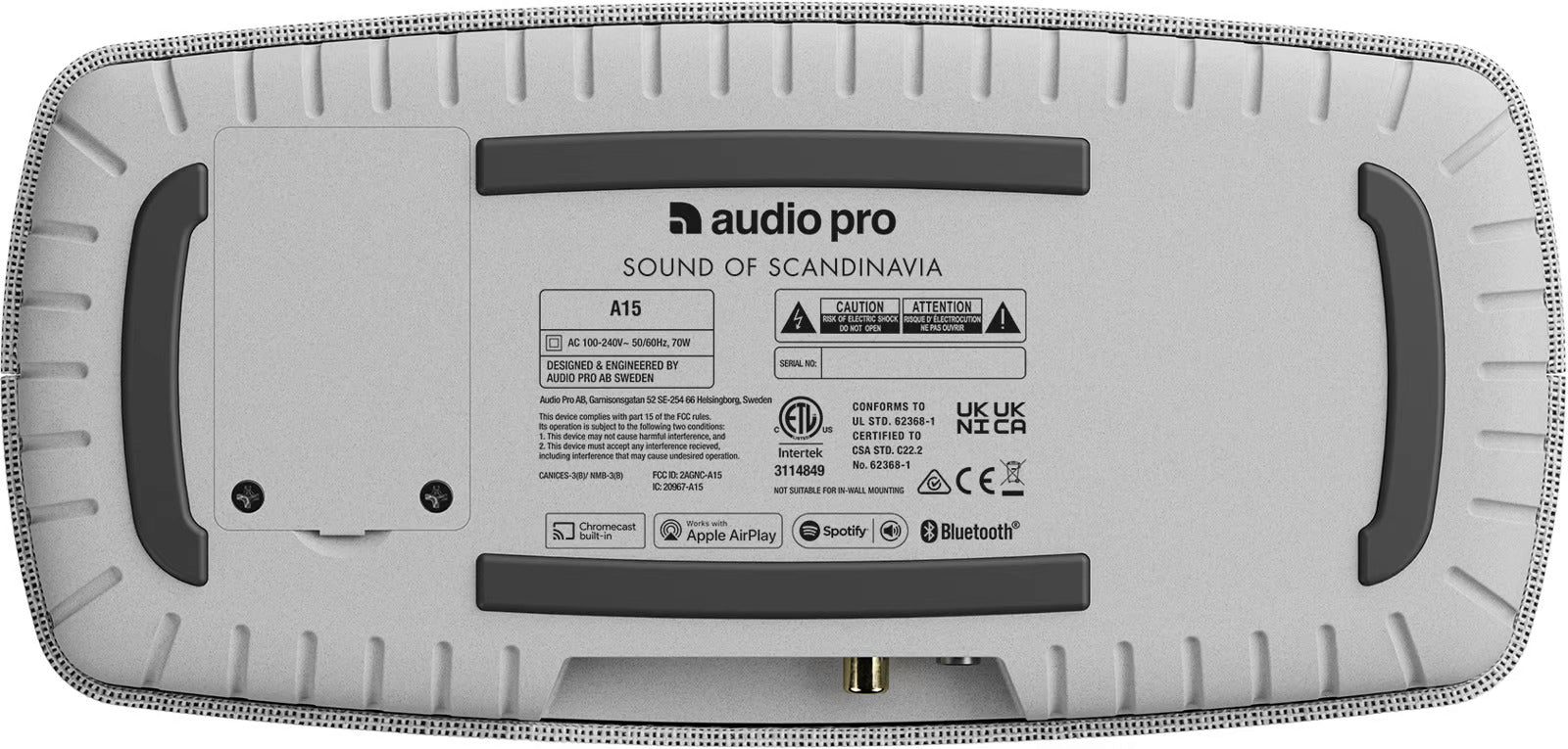 Audio Pro A15 portable speaker shown outdoors, compact design with fabric grille and control buttons on top.
