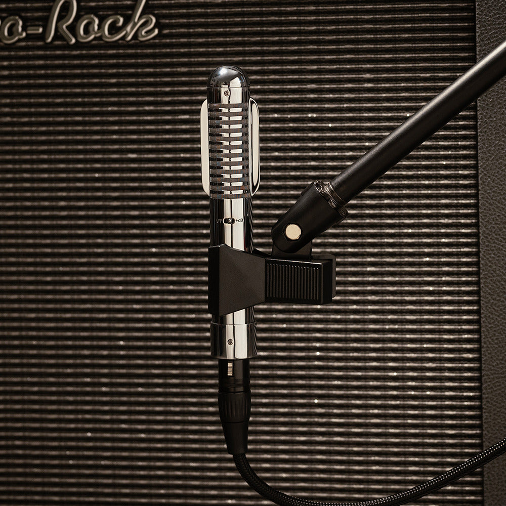Warm Audio Fen-tone ribbon microphone shown in a natural studio setting, highlighting its vintage design and sturdy build.