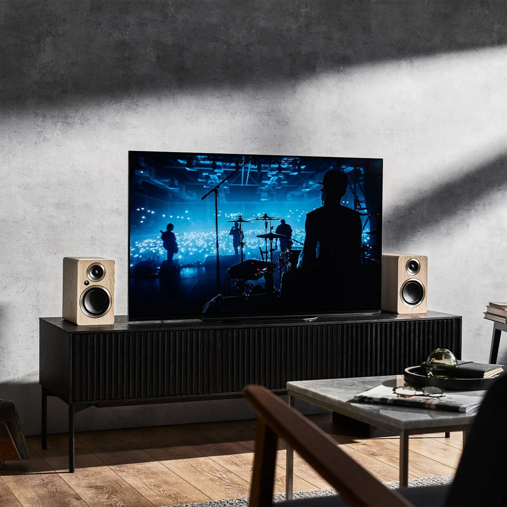 Argon Audio Fenris A4 active bookshelf speakers in black with wood finish, showing the front view with drivers and control knobs.