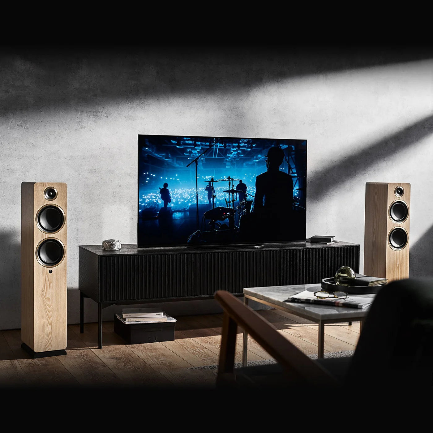 Argon Audio Fenris A55 floorstanding speakers with black ash finish, showcasing their sleek, tall speaker design and wooden texture.