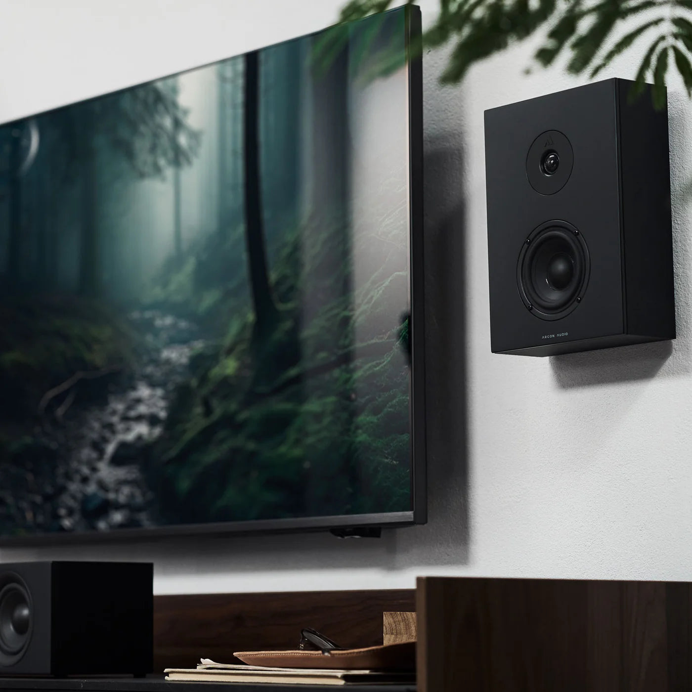 Black Argon Audio Forus 4 in-wall and outdoor speakers mounted on a wall, showcasing sleek design and durable outdoor construction.