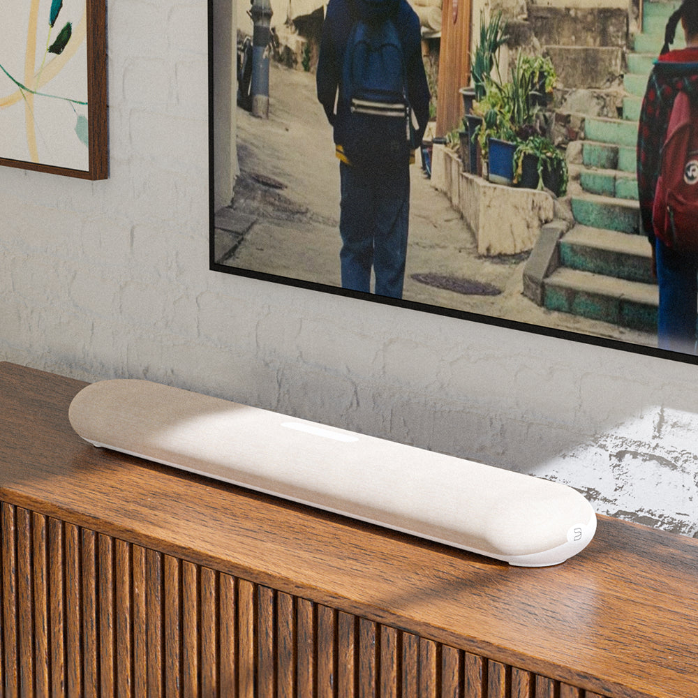 Bluesound Pulse Cinema Mini soundbar with sleek design, positioned in a modern living room setup for high-quality TV audio.