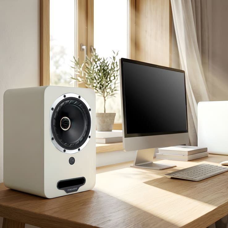 Fyne Audio Cubitt 5 active bookshelf speakers in Arctic White, shown on a desk with a sleek, modern design.