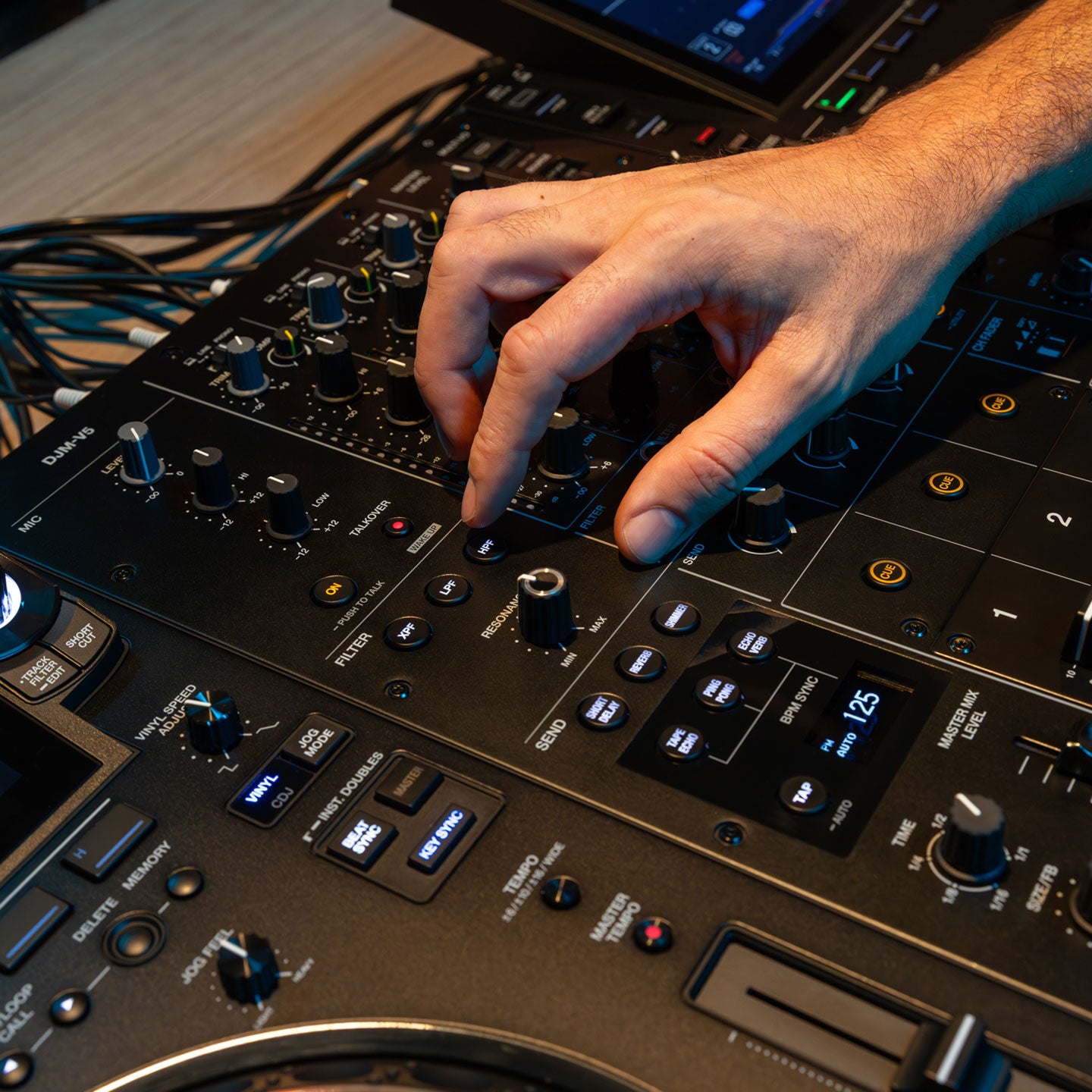 AlphaTheta DJM-V5 DJ mixer with multiple control knobs, faders, and digital display for professional music mixing.