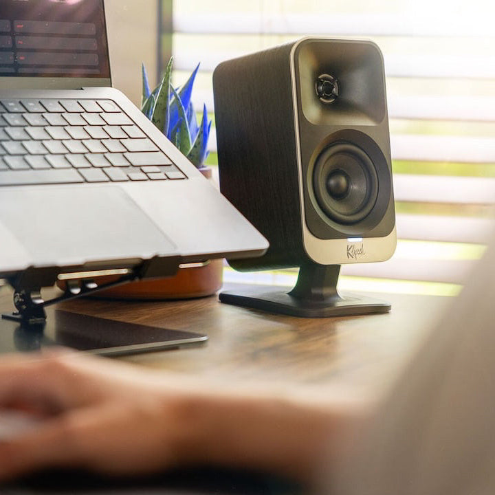 Pair of Klipsch ProMedia Lumina desktop speakers with sleek black design and compact size, positioned on a modern desk setup.
