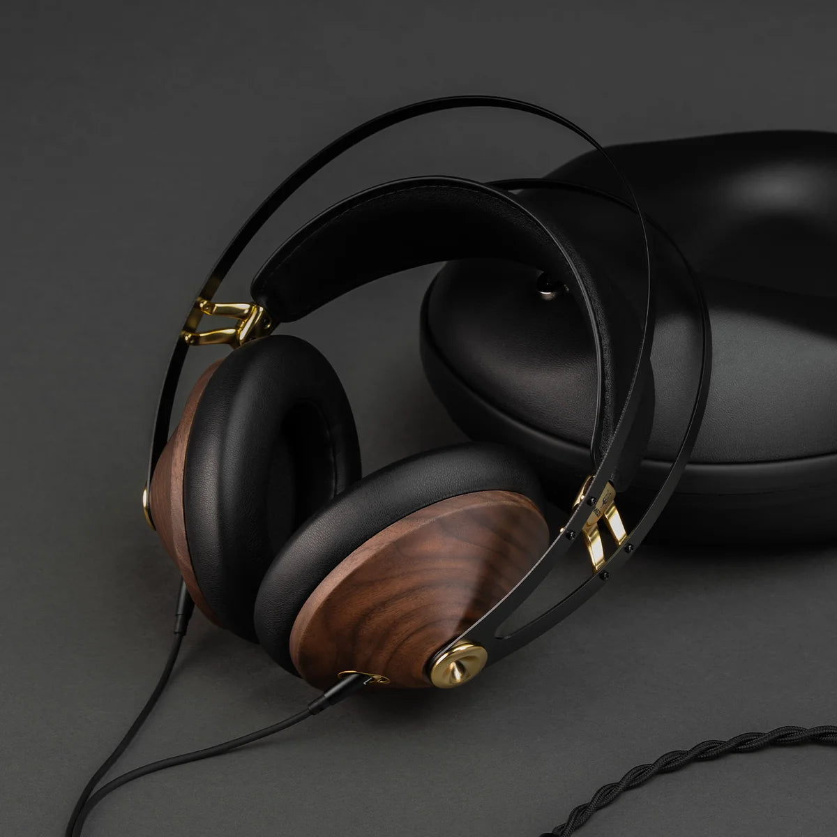 Close-up of Meze Audio 99 Classics 2nd Gen wired headphones showing the black ear cups and silver accents on the headband.