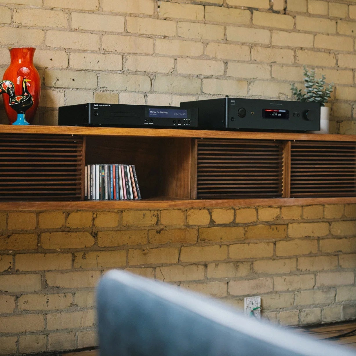 NAD C 589 CD player with a sleek black front panel and digital display, showcasing buttons and disc tray on the left side.