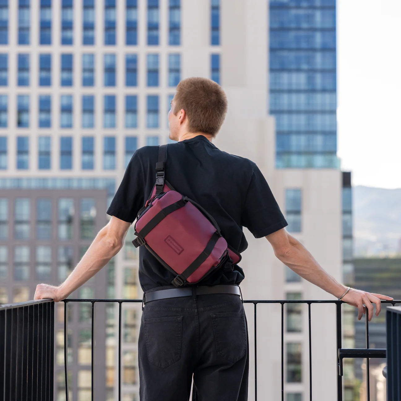 Wandrd Rogue Sling video equipment bag in Rhone Burgundy, compact design with adjustable strap and multiple compartments.