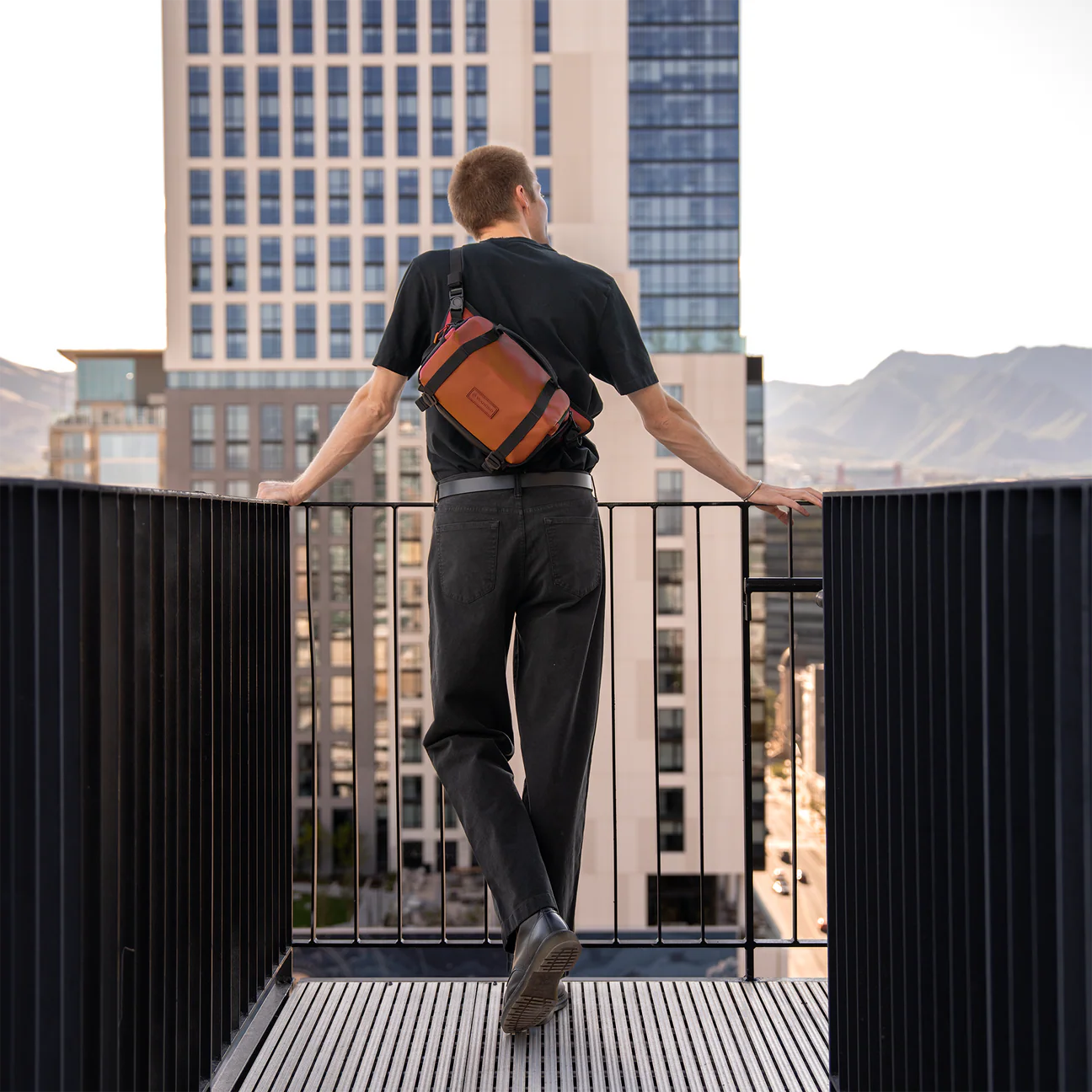 Wandrd Rogue Sling camera bag in Sedona Orange, showcasing compact design with adjustable strap and durable material for video equipment.