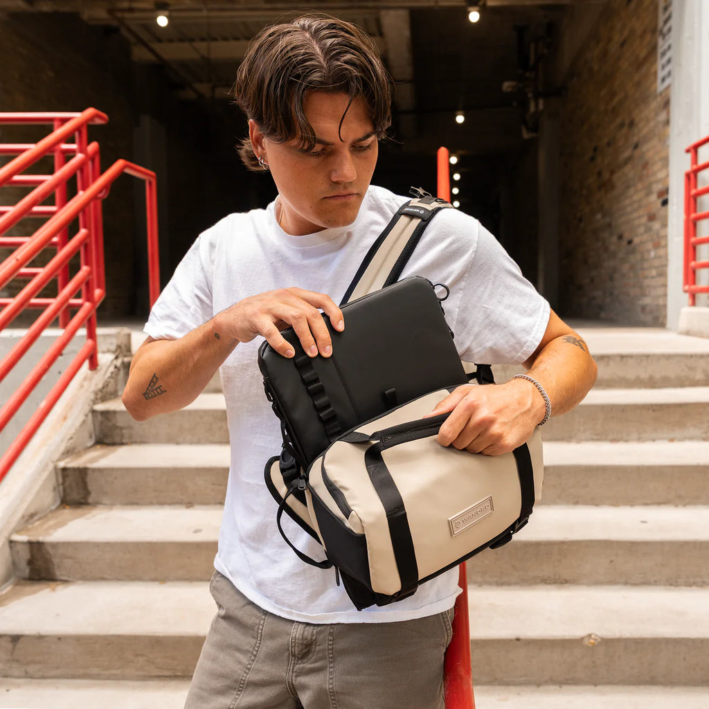 Wandrd Rogue Sling video equipment bag in Yuma Tan color, compact design with adjustable strap and multiple compartments for gear.