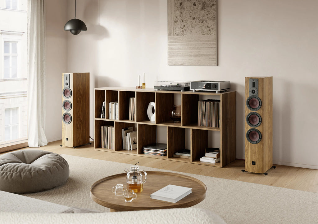 DALI Rubikore 8 passive floorstanding speakers in a living room setting, showcasing their sleek black design and tall speaker profile.