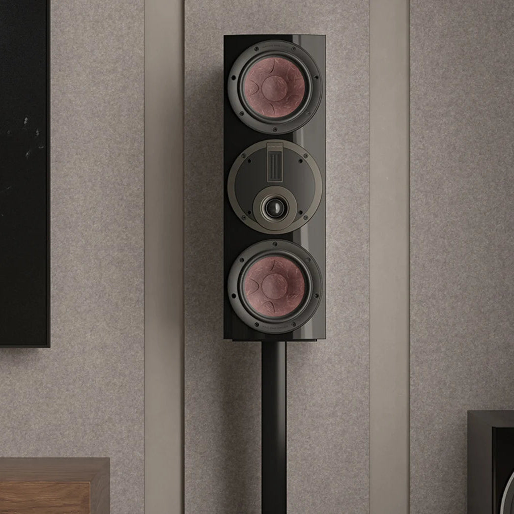 DALI Rubikore Cinema center speaker placed on a living room shelf, showcasing sleek black design and compact size.