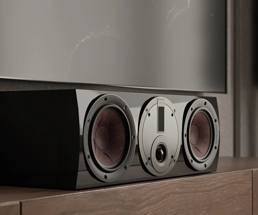 DALI Rubikore Cinema center speaker in a modern living room setting, showcasing sleek design and front grille for home theater audio