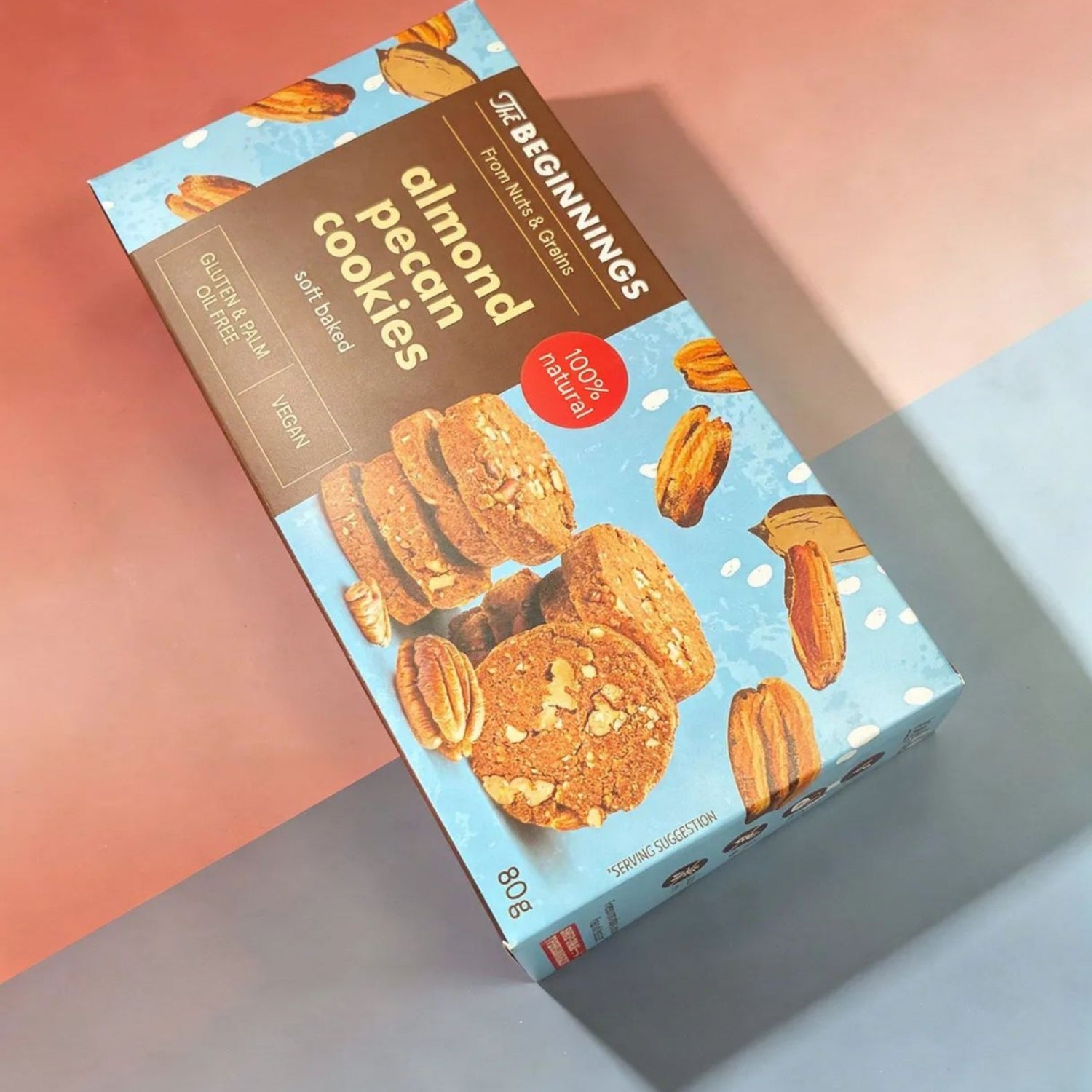 Box of almond pecan cookies on a gradient background