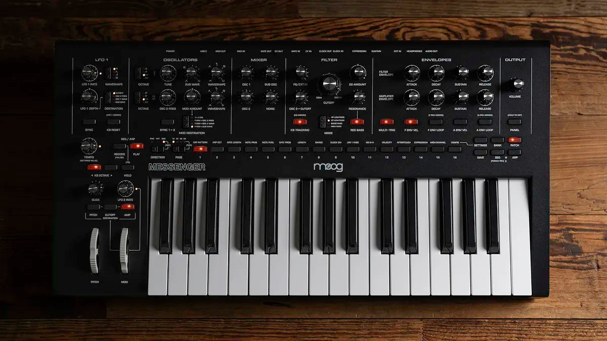Moog Messenger synthesizer with black and silver design, featuring various knobs and buttons on a sleek electronic music device.