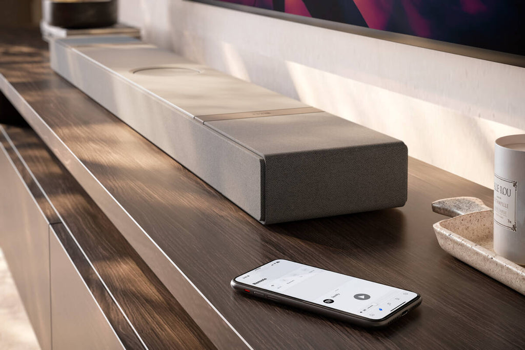 KEF XIO soundbar in silver, designed for TV audio enhancement, with sleek modern look and built-in wireless connectivity.