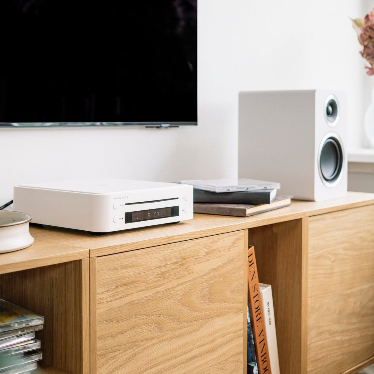 Argon Audio CD1 White on a sideboard in a living room with speakers and a TV