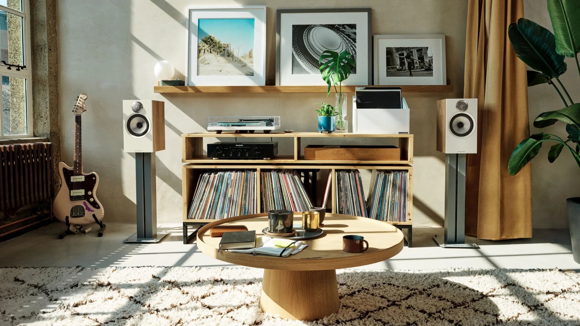Bowers & Wilkins 606 S3 passive bookshelf speakers in oak finish, shown in a stylish home audio setup.
