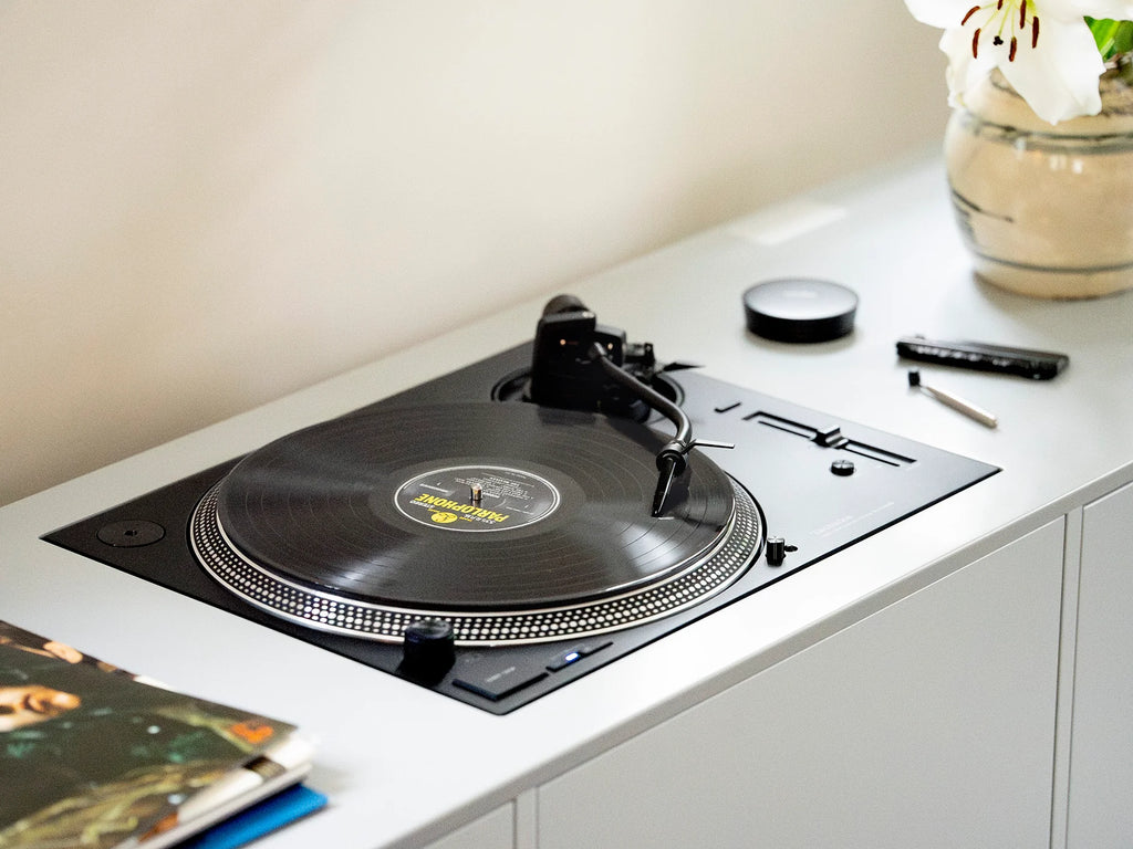 Ortofon Concorde Music Black turntable cartridge mounted on Technics turntable, showing sleek black design and stylus tip.