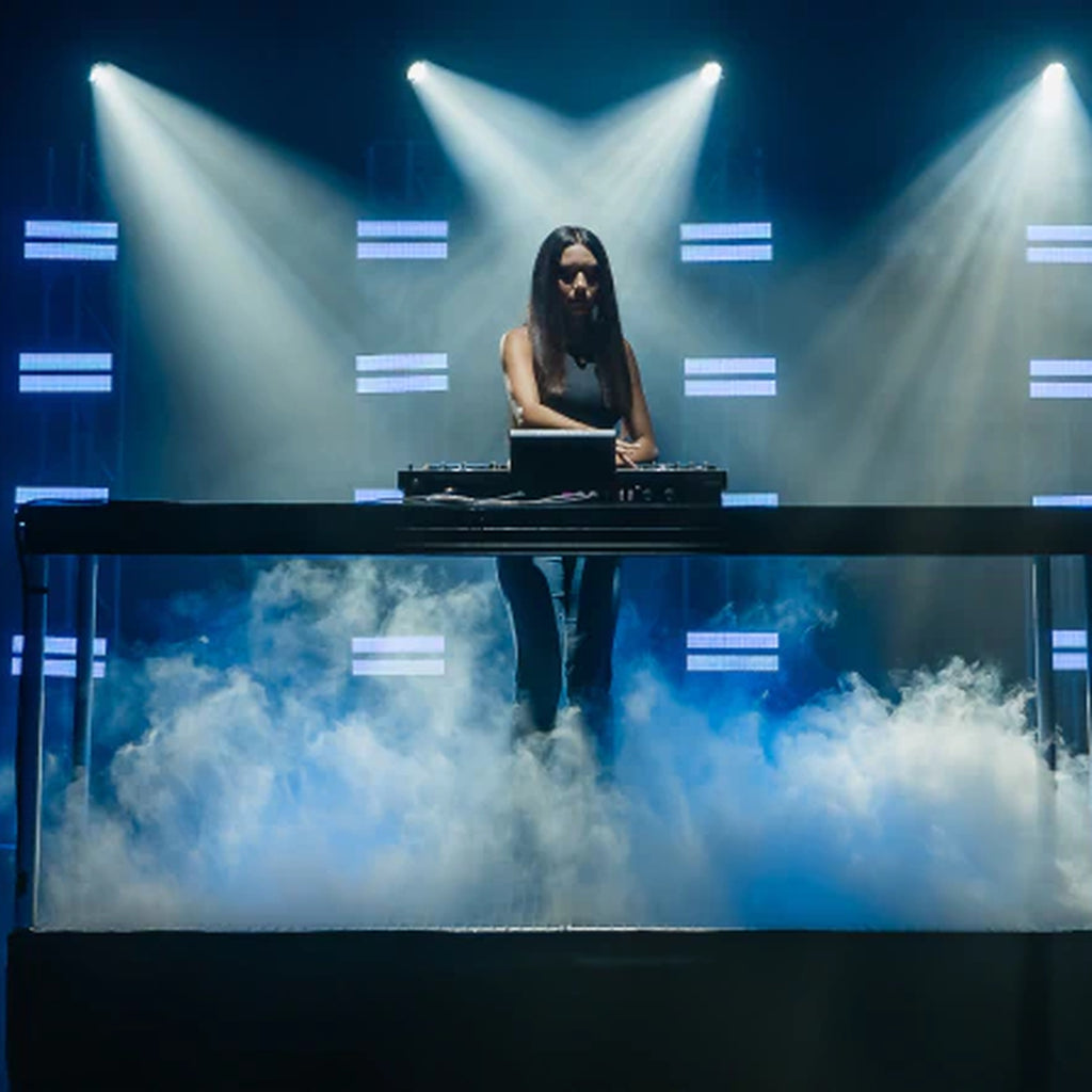 Denon DJ Prime 4 G2, DJ performing on stage with DMX lighting