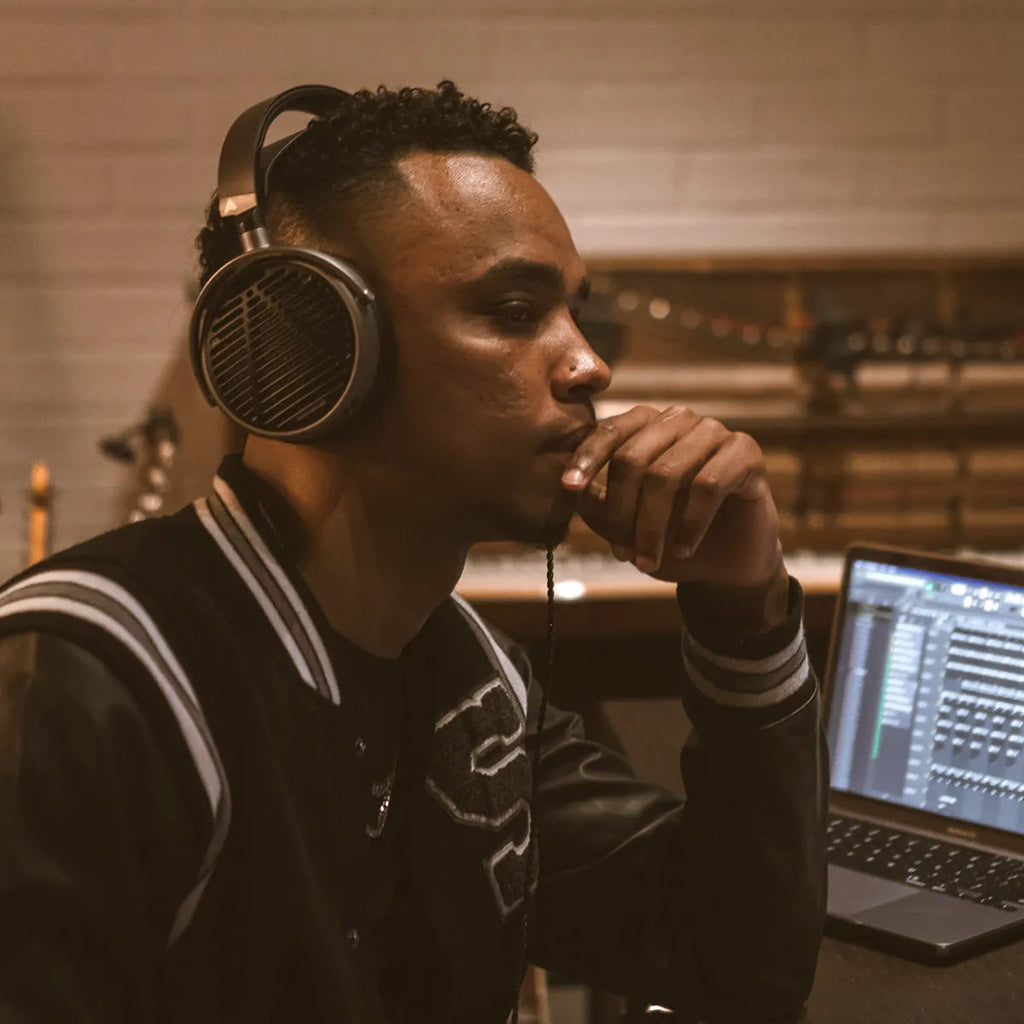 Audeze MM-100 studio headphones with over-ear design, black ear cups, and adjustable headband for professional audio monitoring.