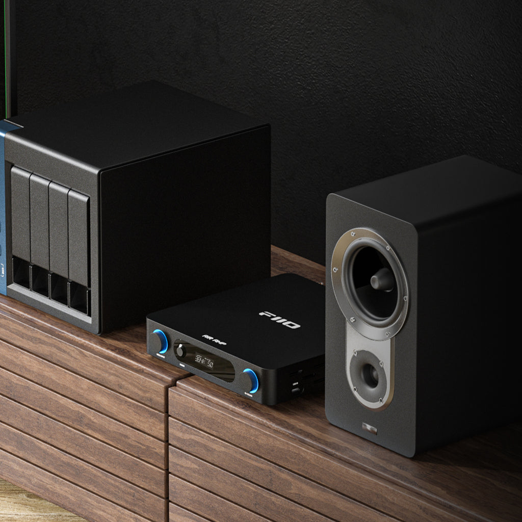 FiiO AIR AMP in Black on a media console with a bookshelf speaker and NAS