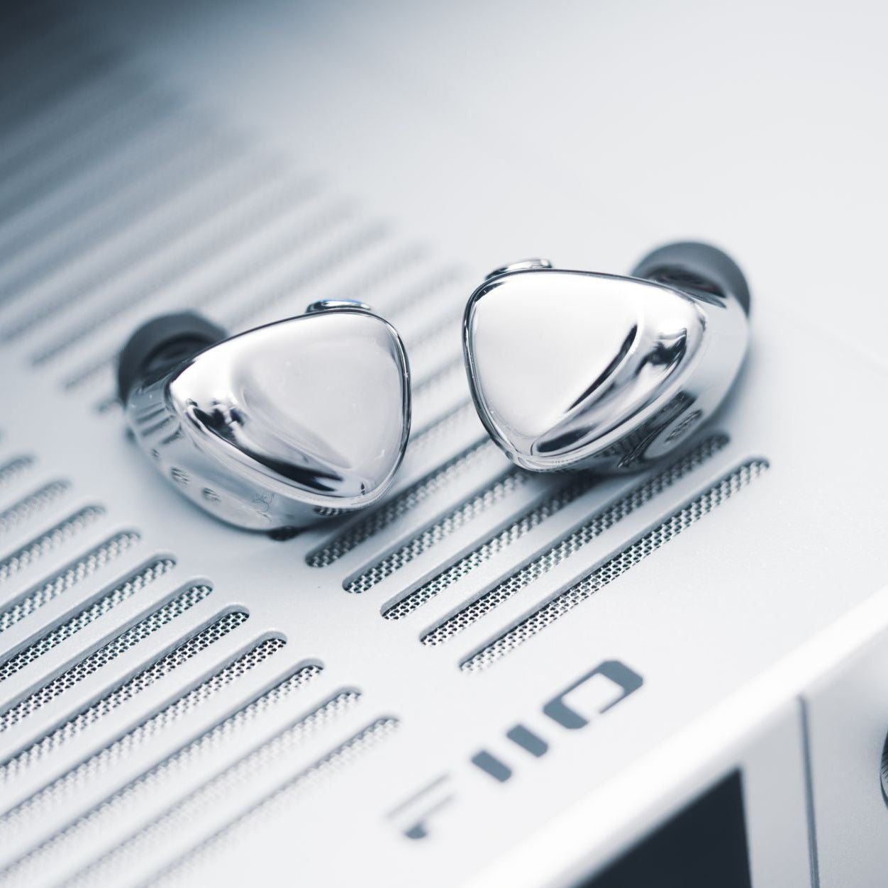 FiiO FX17 in-ear headphones with black silicone tips and sleek design, shown from the side with cable and earbud visible.