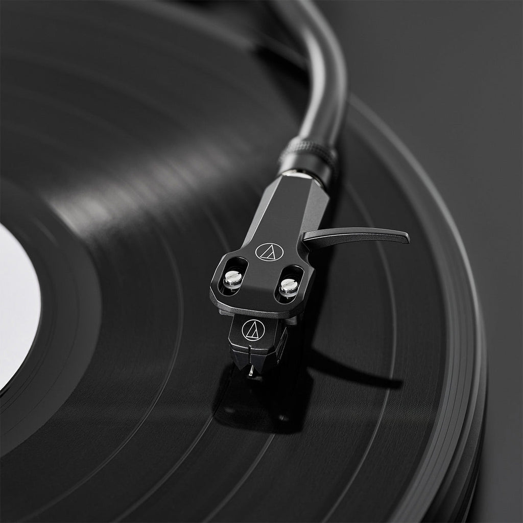 Audio-Technica AT-VM95EBK MM phono cartridge mounted on a turntable, showcasing its black body and stylus for high-quality audio playback.