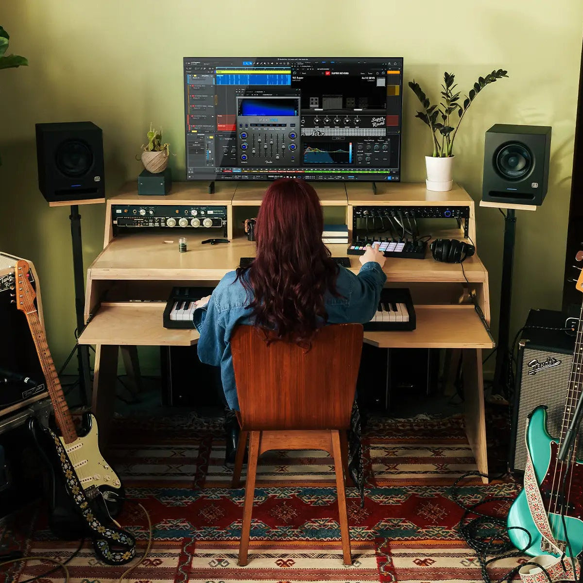 Fender Motion 16 MIDI controller with colorful pads and knobs, shown in a music production setup with laptop and studio equipment.