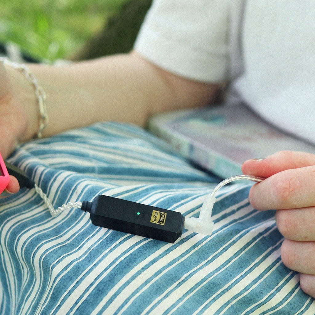 iFi Audio GO link 2 Max connected to a phone outdoors