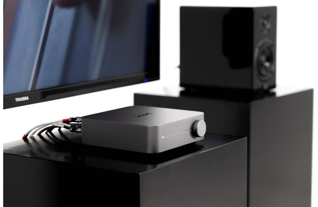 WiiM AMP music streamer device with sleek black design, featuring ports and controls for high-quality wireless audio streaming.
