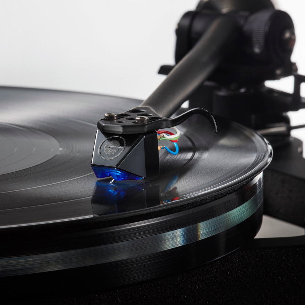 Goldring E4 turntable cartridge with gold-colored body and stylus, angled view showing detailed design and branding.