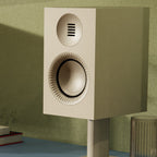 Kanto Audio TUK G2 in Matte White on a sideboard with desktop stands against a green wall